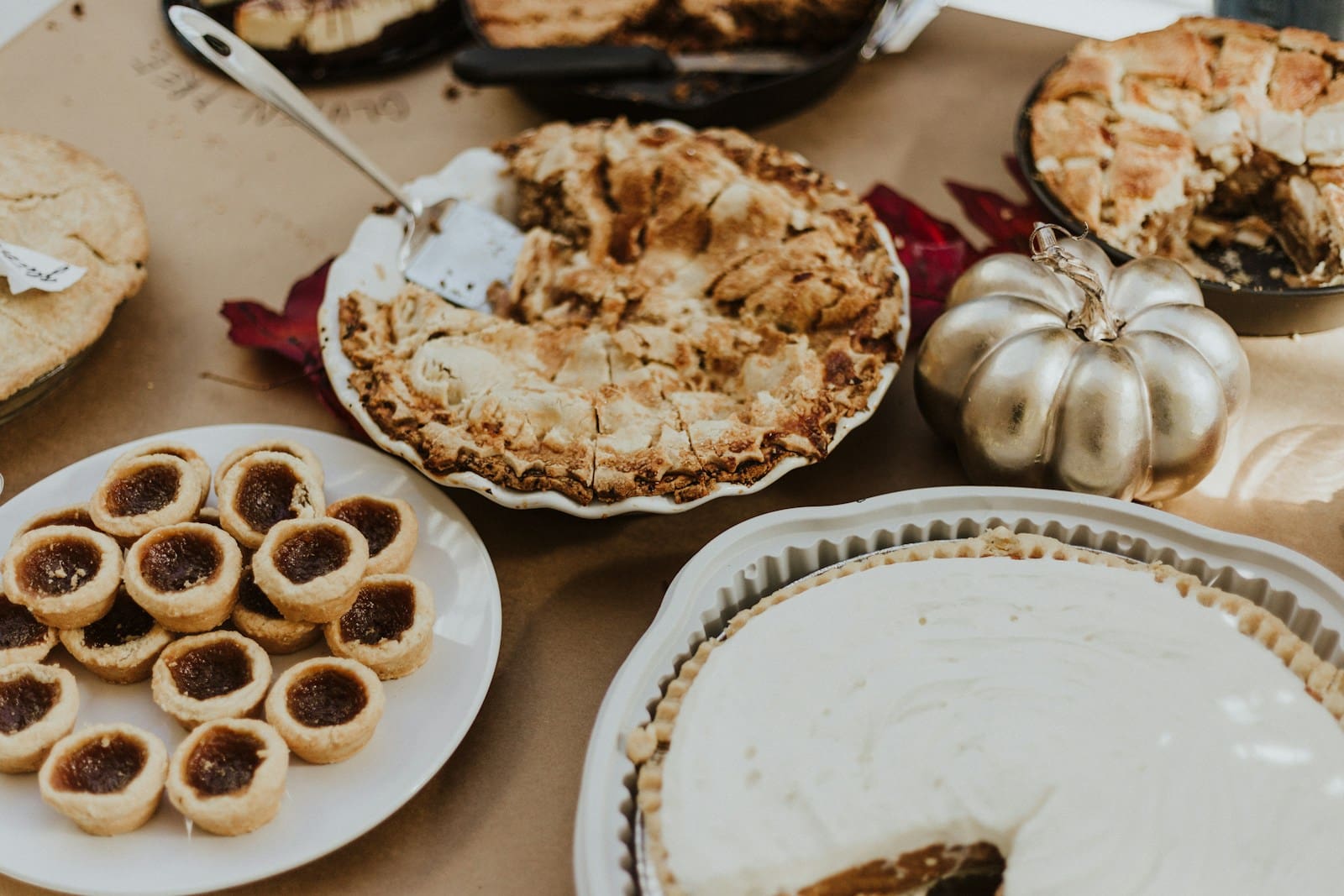 Photo by Priscilla Du Preez 🇨🇦 pastries, pies and pumpkins adorn a brown wooden table