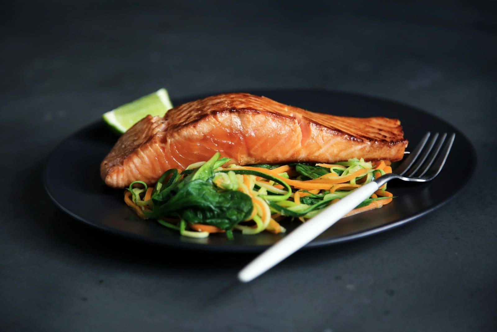 Photo by Caroline Attwood grilled fish, cooked vegetables, and fork on plate
