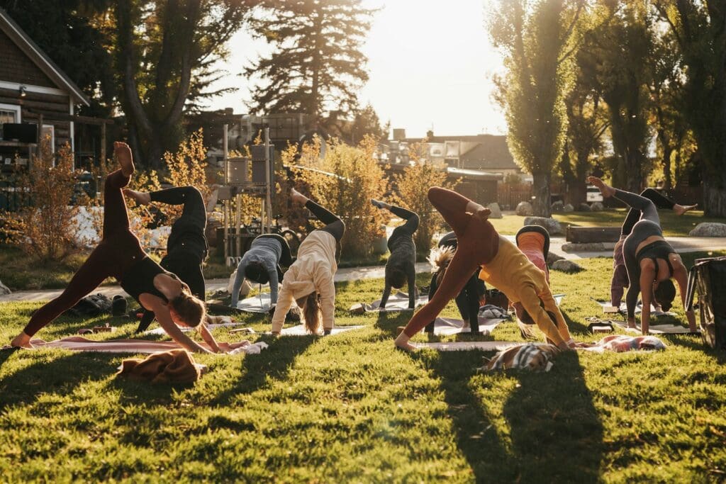 a group of people doing yoga in a park