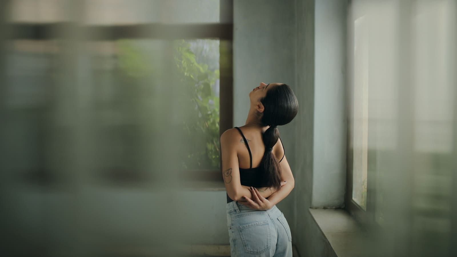 Photo by Hosein Sediqi A woman leaning against a wall with her head in her hands