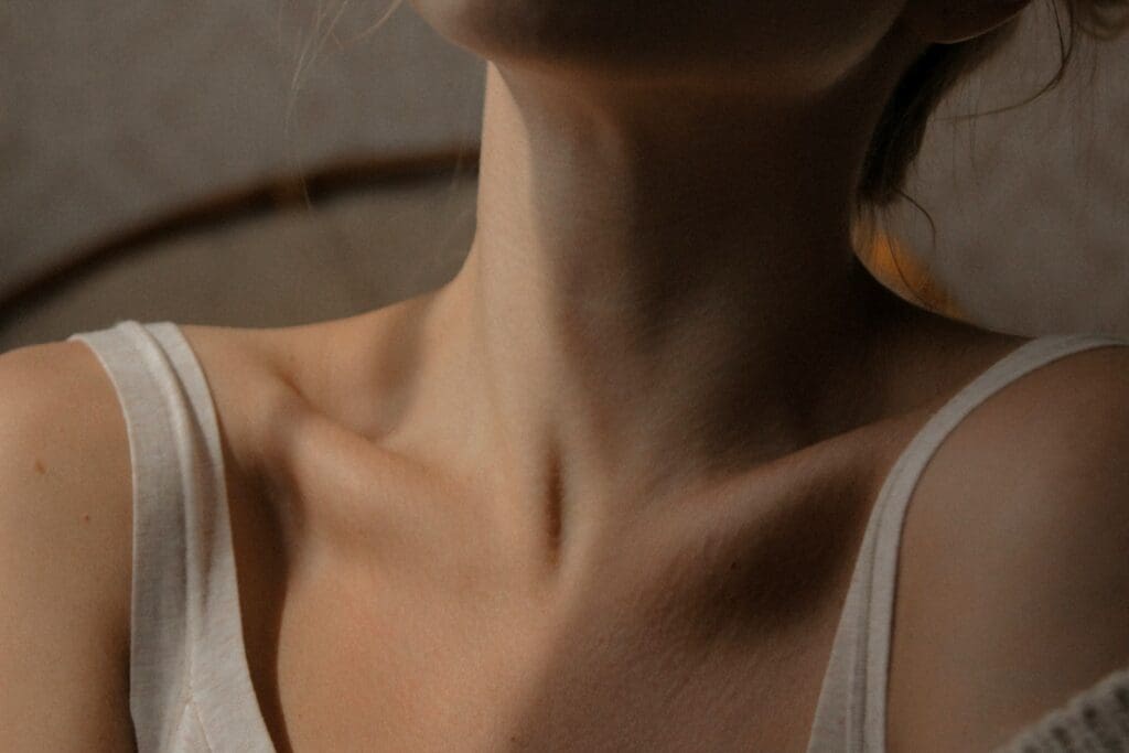 woman in white tank top, you only see her neck and collar bones