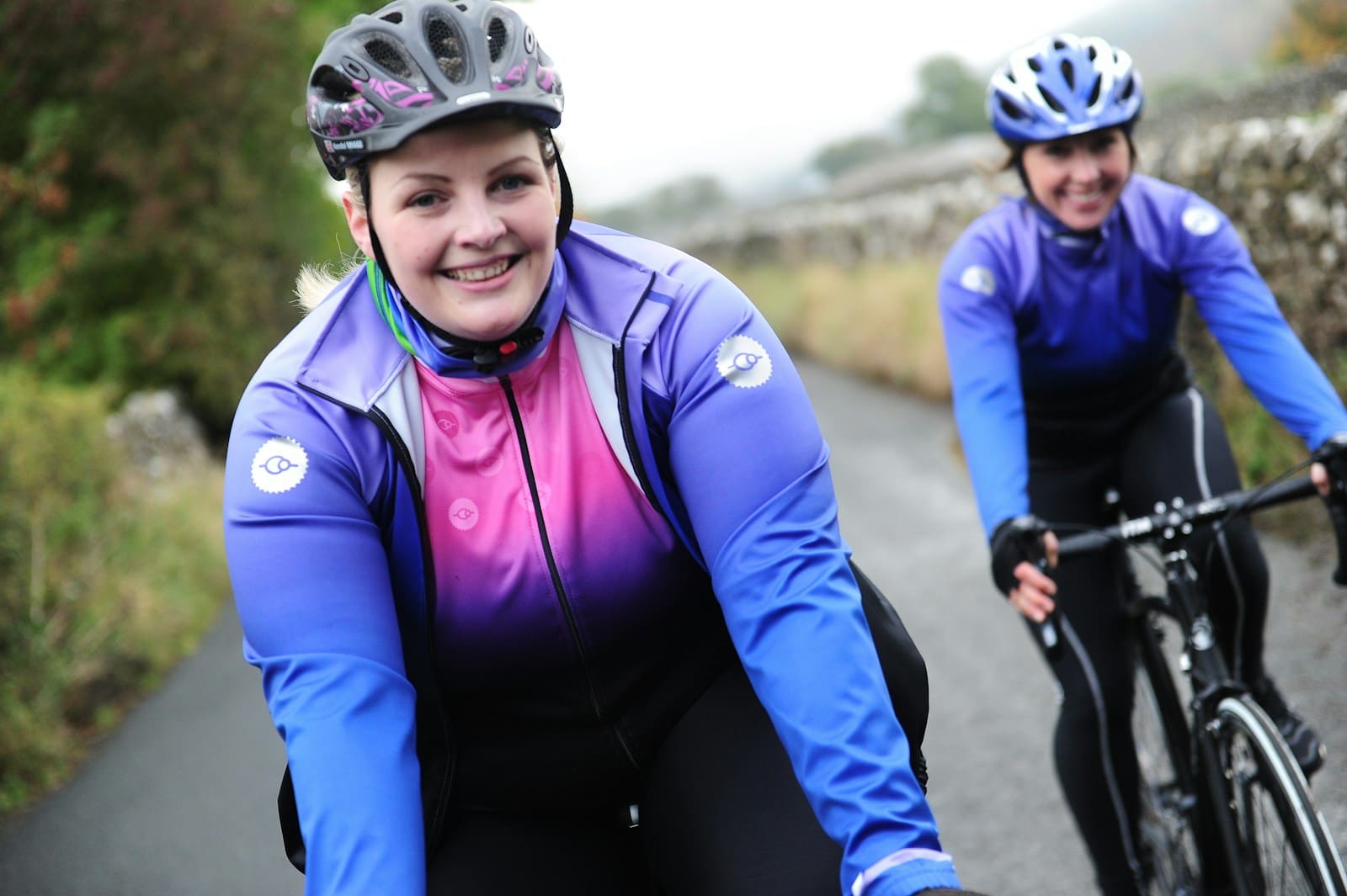 Photo by Fat Lads a couple of women riding bikes down a road