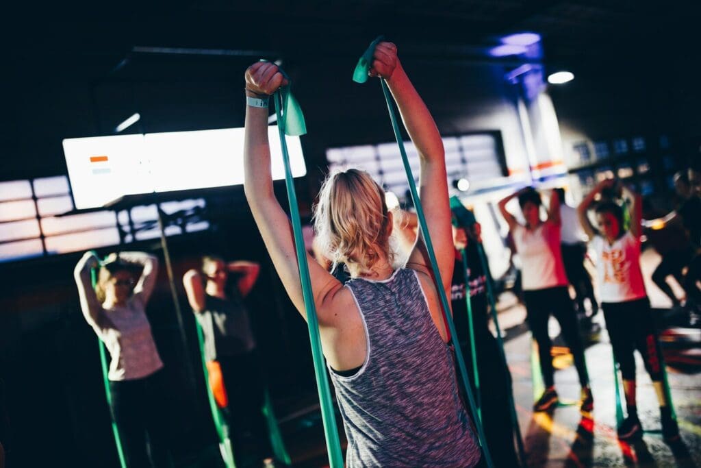 group of people in gym while exercising with resistance bands a type of strength training
