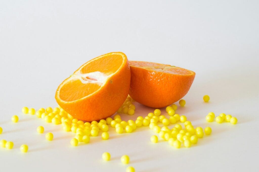 sliced orange surrounded by yellow pills. Citrus fruits are a surprising food that can affect your medications!