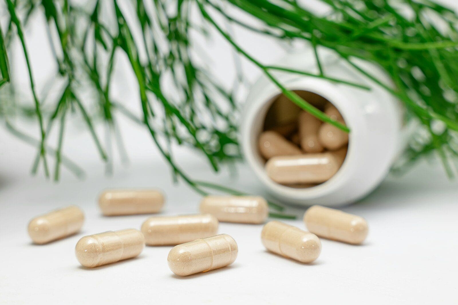 a group of supplements spilling from a bottle and a plant. Amazon supplements are not safe!