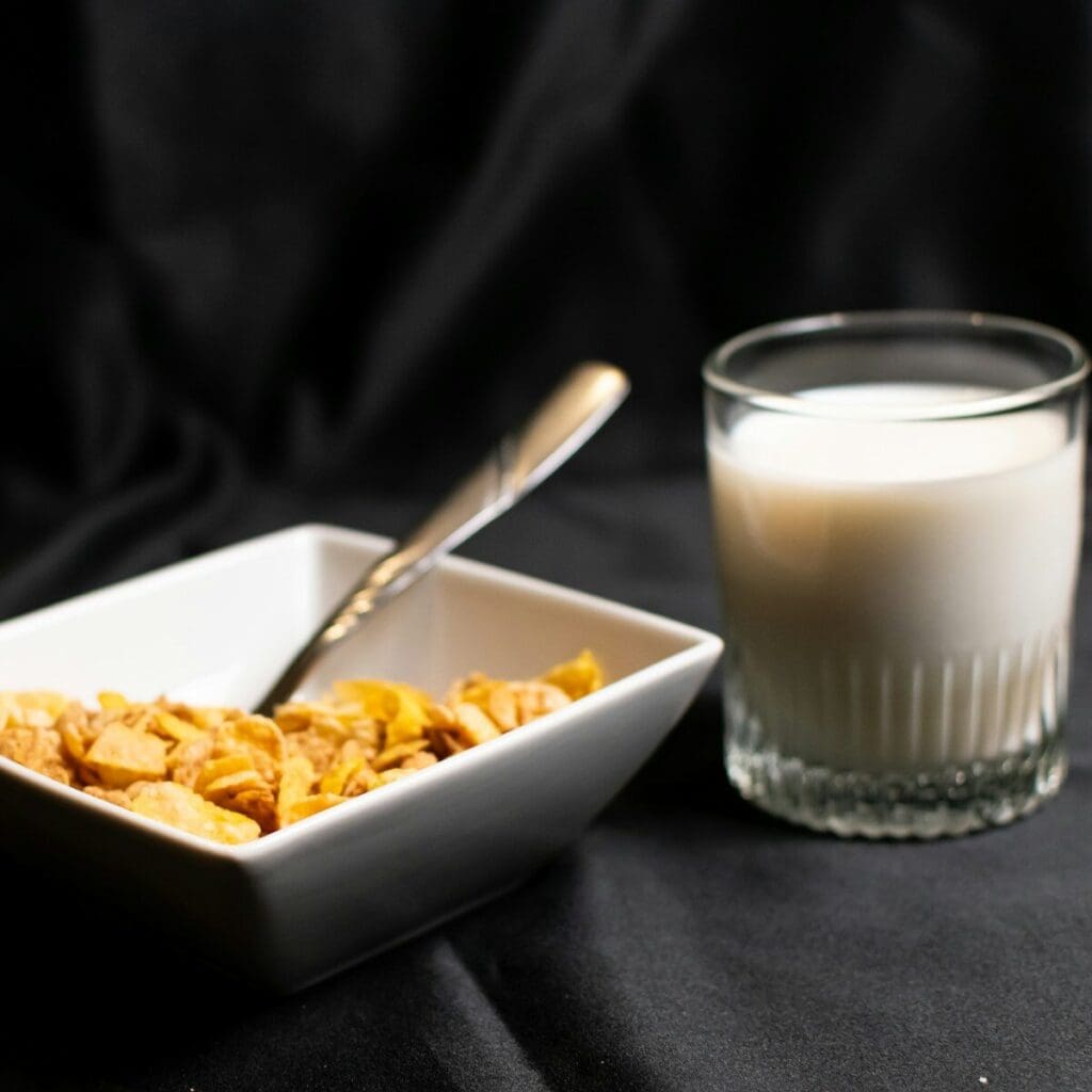 A bowl of cereal next to a glass of milk. Vitamin D is added to cow's milks and plant based milks because not a lot of foods have vitamin D naturally.