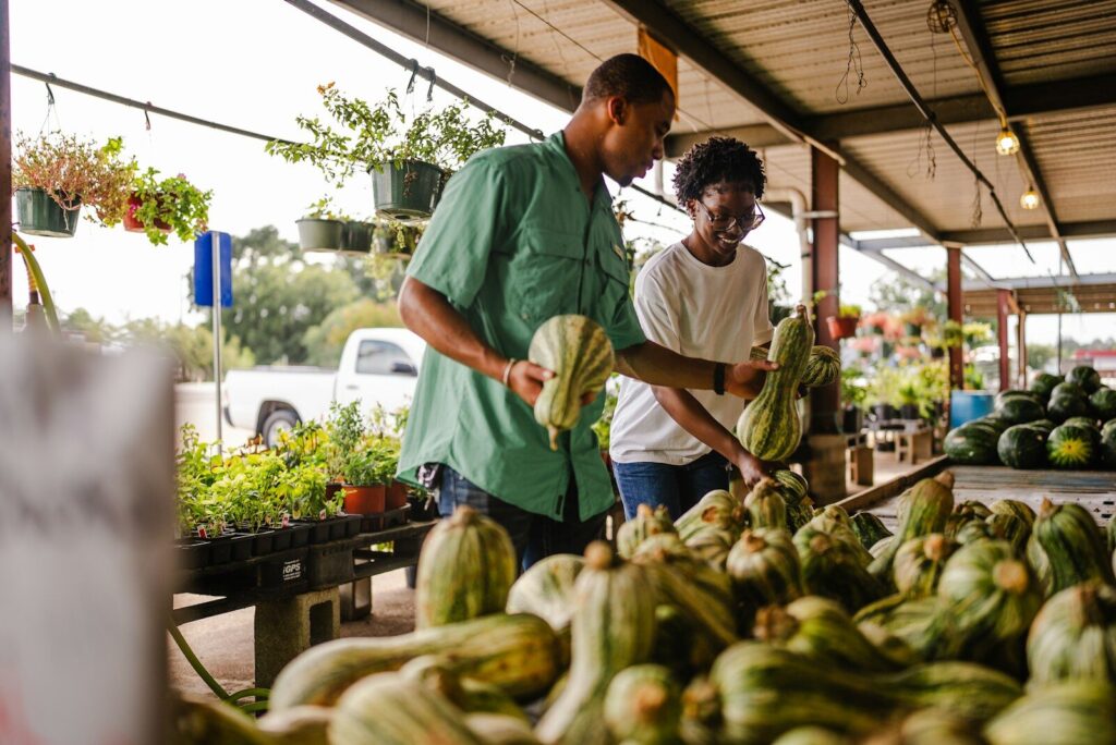 Black couple shopping for gourds at an outdoor Fall market. Fall foods are fresh and good for you!