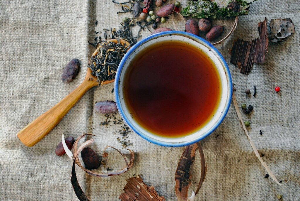 white and brown ceramic mug with herbal tea inside. Herbal tea can be part of your stress relief diet.
