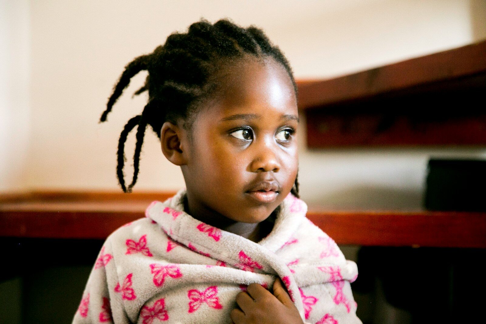 Photo by Keith Banks Little Black girl in white and pink floral robe. She looks like she's feeling under the weather. Hand hygiene and vaccines can help her stay healthy!